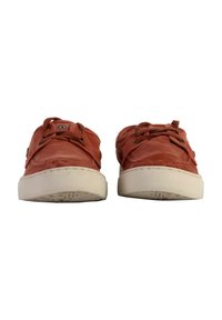 Chaussures en cuir rouge au design arrondi, à lacets et avec des semelles en caoutchouc blanches. Cuir texturé avec des détails de couture visibles.