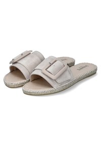 Beige suede slide sandals with a wide strap featuring a rectangular buckle and braided jute sole. Soft texture with open toe design.