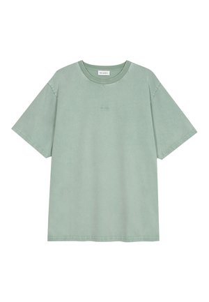 Camiseta de color verde claro de manga corta con cuello redondo, con un pequeño logo en relieve en el centro delantero y una etiqueta blanca dentro del escote.