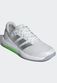 White athletic shoe with a textured mesh upper, three grey stripes, and a green accent on the sole. Features a lace closure and rounded toe.