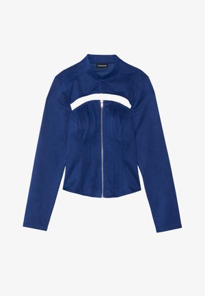 Jachetă bleu marin, confecționată dintr-un material neted, cu mâneci lungi, un design scurt și un fermoar frontal cu un detaliu decupat la piept.