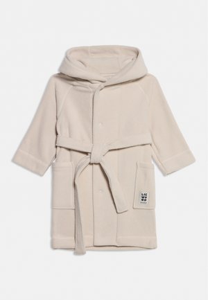 Peignoir à capuche couleur crème avec manches longues, poches avant, ceinture nouée et petite étiquette sur la poche droite.
