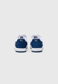 Navy blue suede and white leather sneakers with a white rubber sole. Gold Puma logo on the heel, classic low-top design.