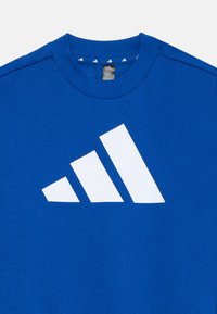 Blue sweatshirt with a white three-stripe logo. Features a ribbed crew neckline and soft fabric texture. Classic athletic design.