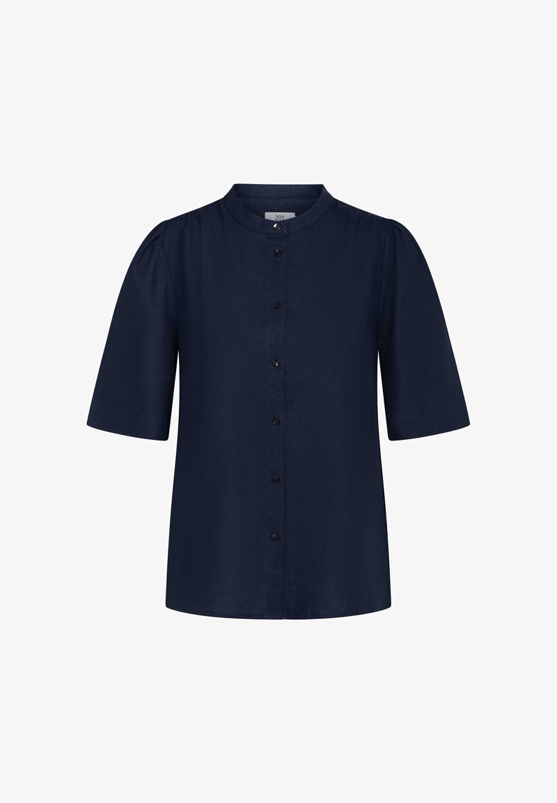 Jūras spēku īsām piedurknēm krekls ar pogu priekšpusi, apaļu dekoltē un izteiktu tekstūru. Iezīmē pūkainas piedurknes un tumšus pogu akcentus.