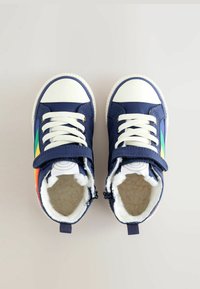 Tumesinised tennisjalatsid valgete kummitaldadega, paelaga kinnitatud disain, velcro rihm, värvilised külgiribad ja pehme, siledapinnaline vooder.