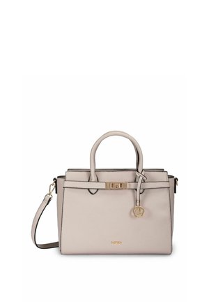 Bolso de mano de cuero beige con dos asas, una correa de hombro desmontable, cierre dorado y un colgante redondo dorado que cuelga de una de las asas.