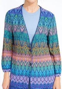 Knit cardigan featuring a chevron pattern in blue, green, pink, and orange tones; button closure, and three-quarter sleeves.