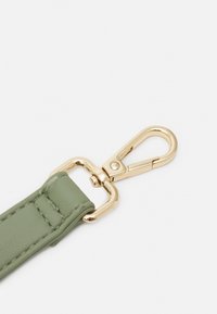 Cinturino in pelle verde con clip e componenti in metallo color oro. Texture liscia con dettagli di cuciture precise. Design sottile e funzionale.