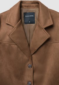 Cappotto in pelle scamosciata marrone con colletto strutturato, due bottoni e cuciture laterali. La fodera interna è di un marrone chiaro uniforme, con il marchio 'CALLIOPE'.