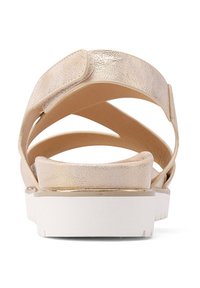 Sandali metallici dorati con cinturini incrociati, una soletta imbottita e una suola platform bianca. Presentano una chiusura in velcro per la regolazione.