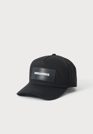 Casquette de baseball noire avec une visière courbée et une plaque rectangulaire en cuir affichant "DSQUARED2" en lettres blanches à l'avant.