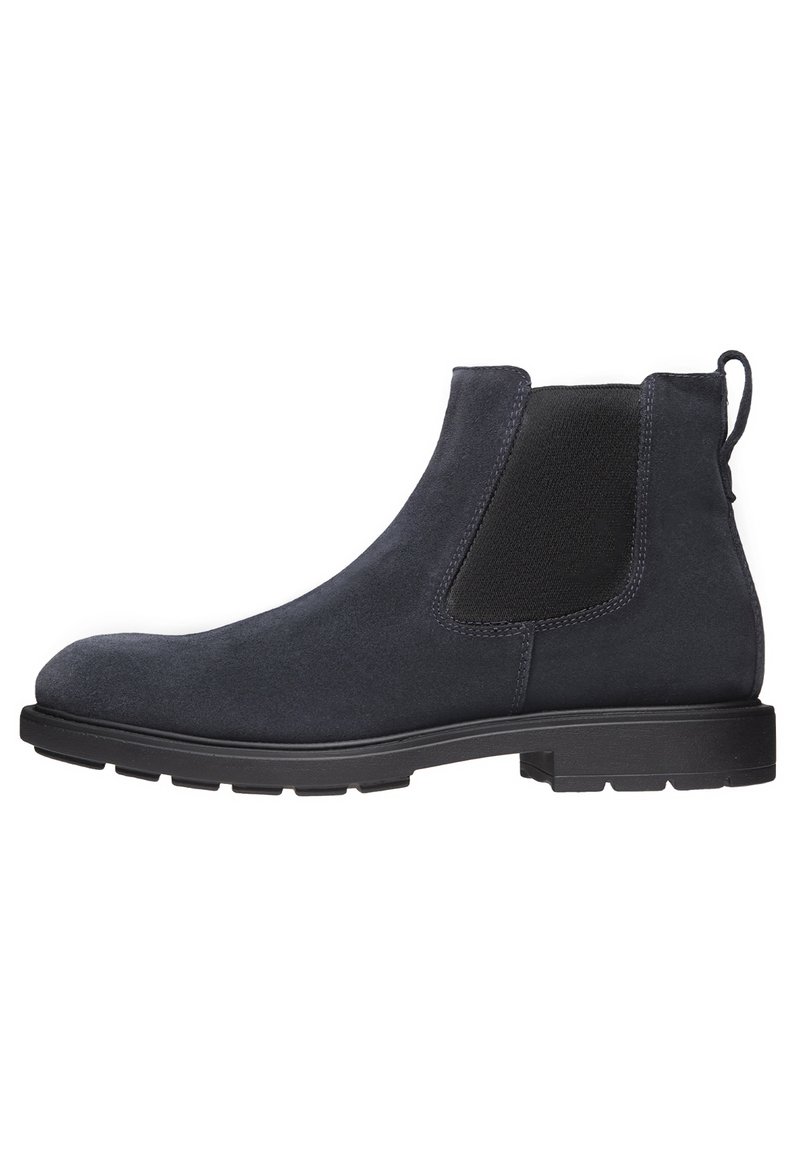 Bottines Chelsea en daim noir avec des panneaux latéraux élastiques, bout rond et semelle en caoutchouc texturée. Dotées d'une bride à l'arrière pour un enfilage facile.