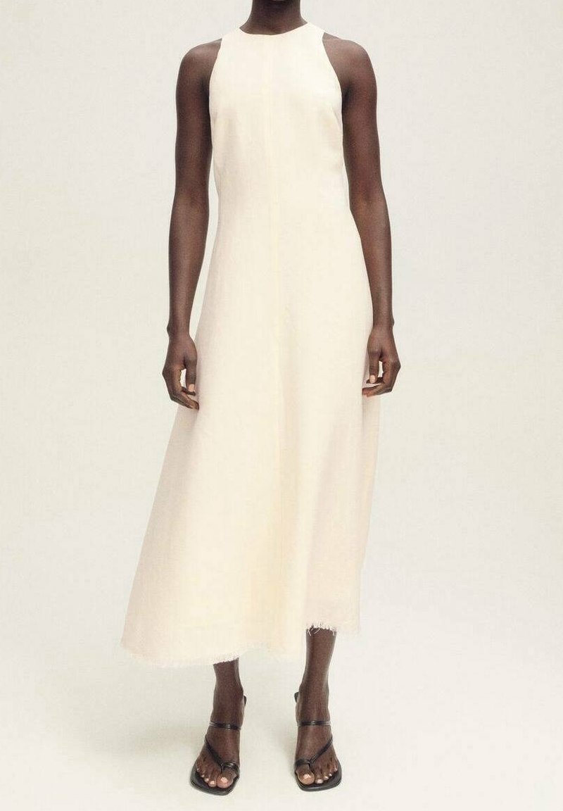 Maksimekko pehmeässä, off-white-kankaassa, jossa on korkea kaula-aukko, ilman hihansuita ja raakareunat. Yhdistetty mustiin sandaaleihin.