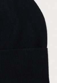Black knitted beanie hat with a ribbed cuff. Soft texture, rounded top, and uniform color. No visible patterns or hardware accents.