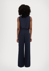 Marineblå uten ermer jumpsuit med tettsittende overdelsdesign og vide ben, laget av glatt stoff og med høy midje.