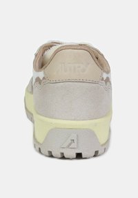Beige su�ède sneakers met textuurpanelen, een gewatteerde kraag en een lichtgele zool. Bevat het merklogo in reliëf op de hiel.