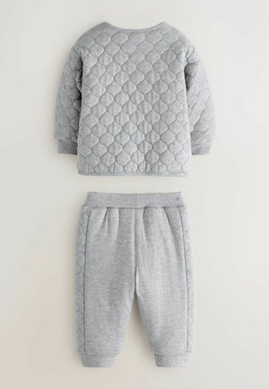 Hellgrauer gesteppter Sweatshirt mit Rundhalsausschnitt und langen Ärmeln, kombiniert mit grauen Sweatpants mit seitlichen Falten und umgeschlagenen Säumen.