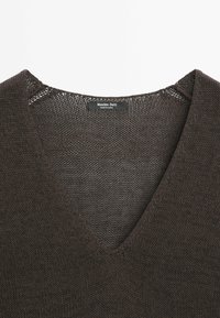 Ciemnobrązowy dziany sweter z dekoltem w serek z metką Massimo Dutti wewnątrz kołnierza, wyprodukowany w Chinach.