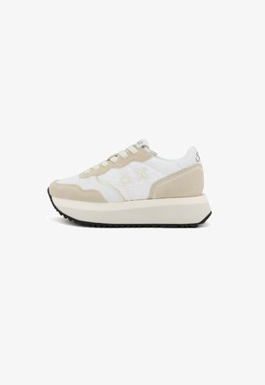 Zapatillas en beige y blanco con materiales de gamuza y malla, puntera redonda, suela plana y detalles decorativos. Diseño simple con sistema de cordones.