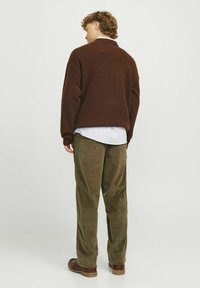 Brown textured sweater with a wide collar, paired with olive corduroy pants. The outfit is completed with brown shoes.