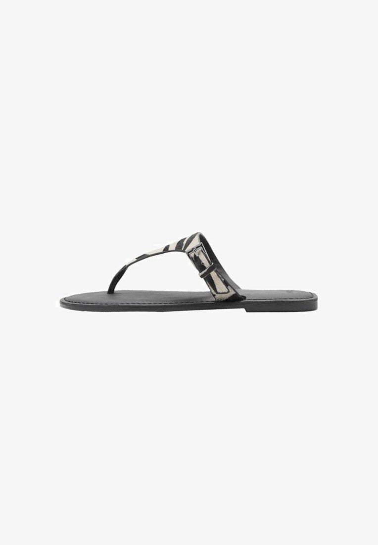 Litteinen flip-flop-sandaali, jossa on musta pohja, raidallinen kangasremmi, jossa on solkikoriste. Teksturoitu pinta ja minimalistinen muotoilu.
