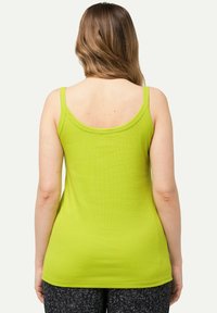 Camiseta sin mangas verde acanalada con tirantes finos, con espalda en forma de escote redondo. Textura suave, diseño ajustado y estilo de longitud media.