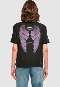 Černé tričko s grafikou fialových andělských křídel a svatozáře na zadní straně. Uprostřed je nápis "ANGELS CLUB". Krátké rukávy, volný střih.