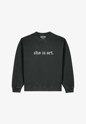 Felpa nera in morbido misto cotone, con scollo a girocollo e polsini a costine. Il testo "she is art." è ben visibile in bianco.