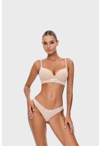 Beige Push-up-BH und passender Tanga aus glattem Material mit subtiler glänzender Oberfläche, verstellbaren Trägern und Logodetails auf der Vorderseite.