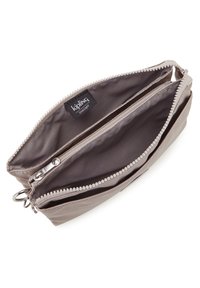 Dragkedjefodral i ljusgrått tyg med en slät yta. Har dubbla fack och en Kipling-logotagg inuti. Dekorerad med pärlade dragkedjeslut.