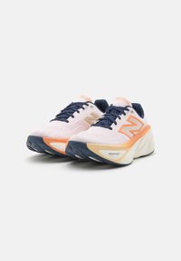 Zapatillas deportivas rosa claro con acentos en navy, que cuentan con un upper texturizado, detalles en naranja y una suela blanca gruesa con una forma dinámica.