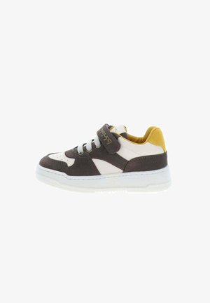 Zapatilla infantil en blanco, gris oscuro y amarillo con cordones y una correa de velcro sobre un fondo blanco.
