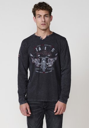 T-shirt a maniche lunghe nera realizzata in cotone, con una grafica di una moto vintage accompagnata da testo. Texture morbida e design a scollo a V.