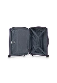 Valise rigide violette avec une fermeture éclair en argent, intérieur avec un revêtement à rayures gris, poche en mesh et sangles croisées pour maintenir le contenu.