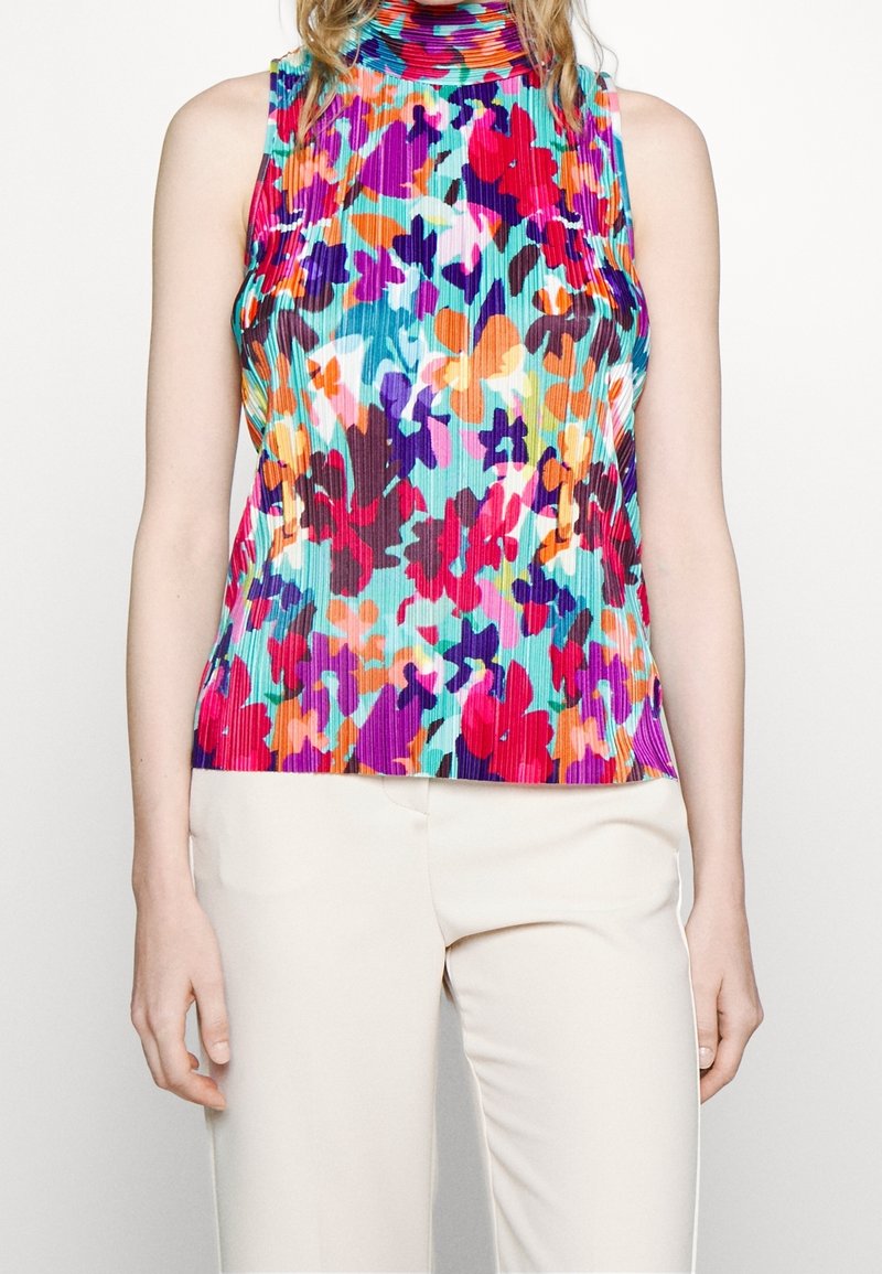 Top sin mangas de canalé en colores vivos con un cuello alto. Patrón floral en colores vibrantes sobre un fondo azul claro.