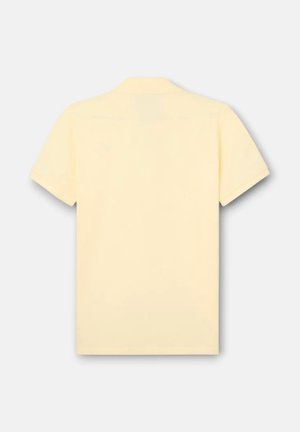 Polo de manga corta de color amarillo claro liso mostrado desde atrás con cuello clásico sobre un fondo blanco.