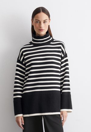 Swartrutete turtleneck genser med løs passform, ribbestruktur, vide ermer og solid svart kant nederst.
