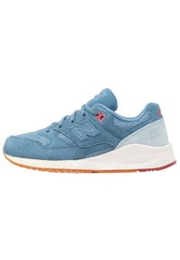 Baskets New Balance en daim bleu avec semelle intermédiaire blanche, semelle en gomme, accents d'œillets roses et texte "530 ENCAP" sur le contrefort du talon.