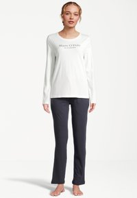 Witte blouse met lange mouwen met "Marc O'Polo" in zwart gedrukt, gecombineerd met donkerblauwe broek, van katoen, reguliere pasvorm, minimalistisch ontwerp.