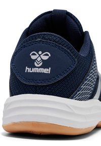 Marineblaue Mesh-Sneaker mit weißer Sohle, die ein auffälliges Logo und diagonale weiße Akzentlinien an der Seite aufweisen. Strukturierte Oberseite.
