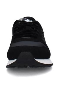 Scarpa sportiva nera con tomaia in camoscio e rete, lacci piatti e suola ammortizzata. Presenta una punta arrotondata e una suola intermedia bianca a contrasto.