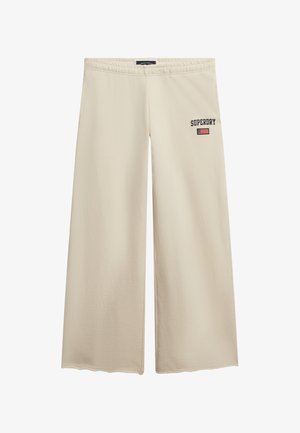 Beige wide-leg pants made from smooth fabric, featuring an elastic waistband and embroidered "SUPERDRY" logo with a small American flag detail.