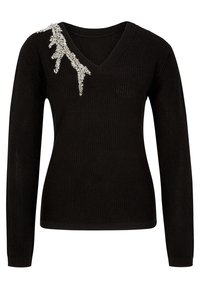 Pull en maille noir avec col en V, manches longues et un ornement en argent décoratif sur une épaule. Tissu texturé, coupe décontractée.