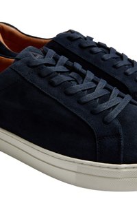 Granatowe zamszowe sneakersy o strukturalnej powierzchni, w tonowanych sznurowadłach i kontrastującej kremowej gumowej podeszwie. Minimalistyczny design z akcentem na języku.