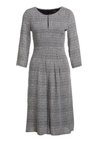 Vestido de patrón en blanco y negro con mangas tres cuartos, escote redondo y falda plisada. La tela parece suave con una cintura entallada.