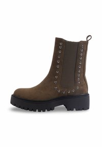 Bottines en daim marron avec des panneaux élastiques sur les côtés, des accents cloutés le long des côtés, un bout arrondi et une semelle épaisse noire.