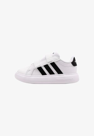 Zapatilla blanca de Adidas con rayas negras, dos tiras de Velcro, cuello acolchado y suela acolchada con la etiqueta "BUBBLECOMFY" en el lateral.