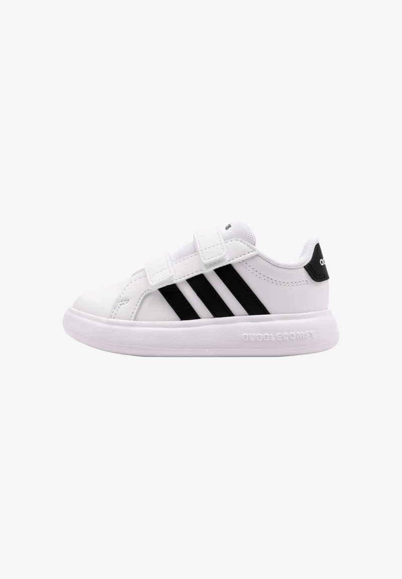 Baskets blanches Adidas avec des rayures noires, deux sangles Velcro, un col rembourré et une semelle coussinée portant l'inscription "BUBBLECOMFY" sur le côté.