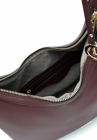 Sac à main en cuir bordeaux avec fermeture éclair, poche intérieure zippée et doublure à rayures grises ; équipé de ferrures dorées et d'une forme structurée.